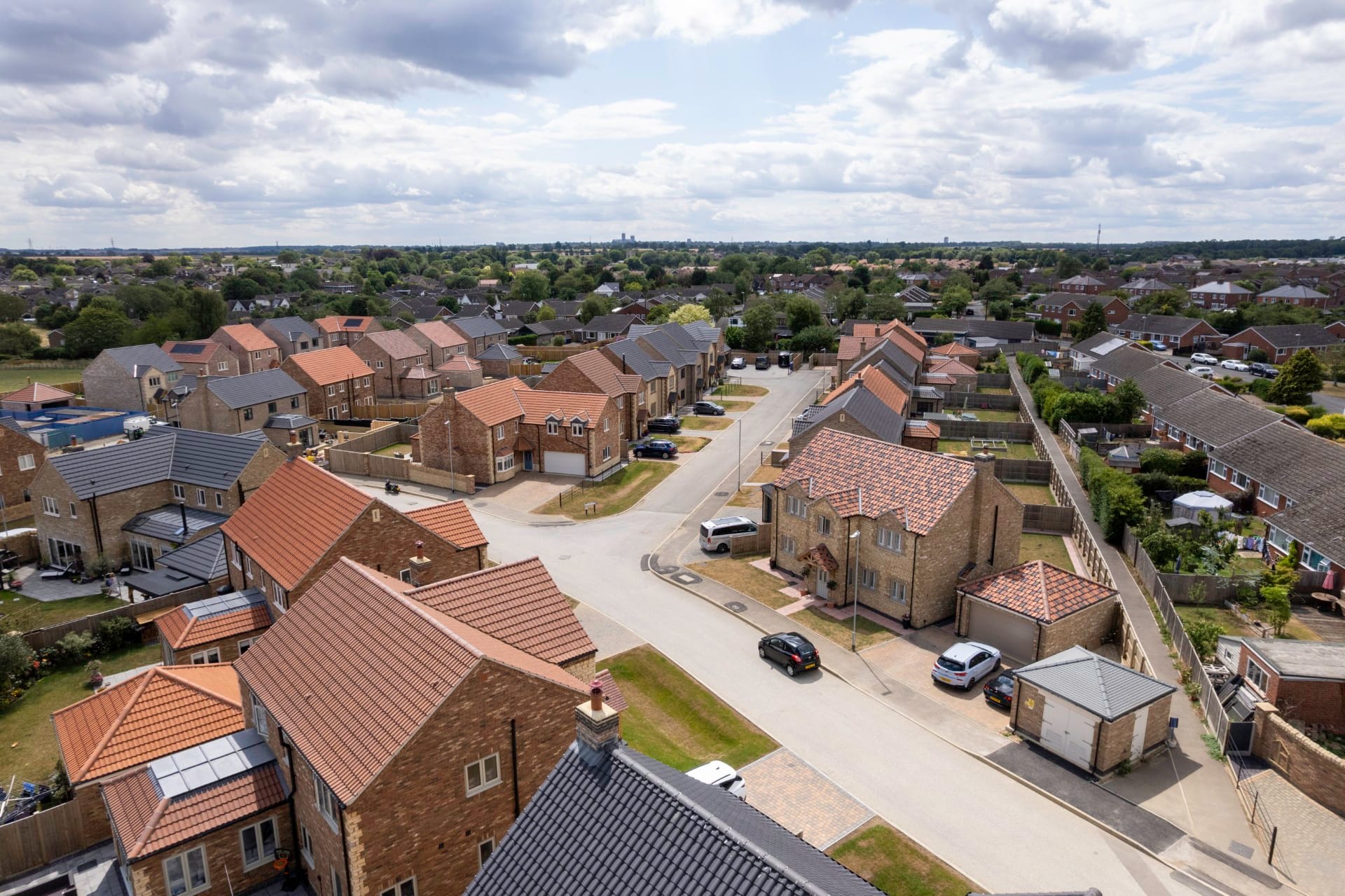 Drone shot showing a housing development with a junction in the centre
