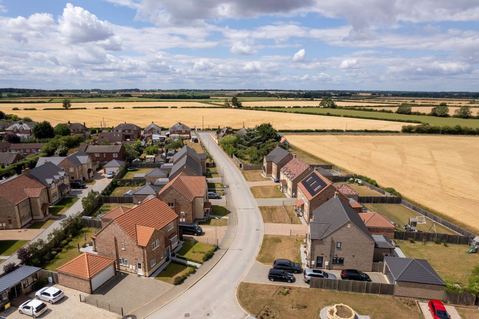 Drone shot over the Cricketers Walk high street showing many houses lining a small street